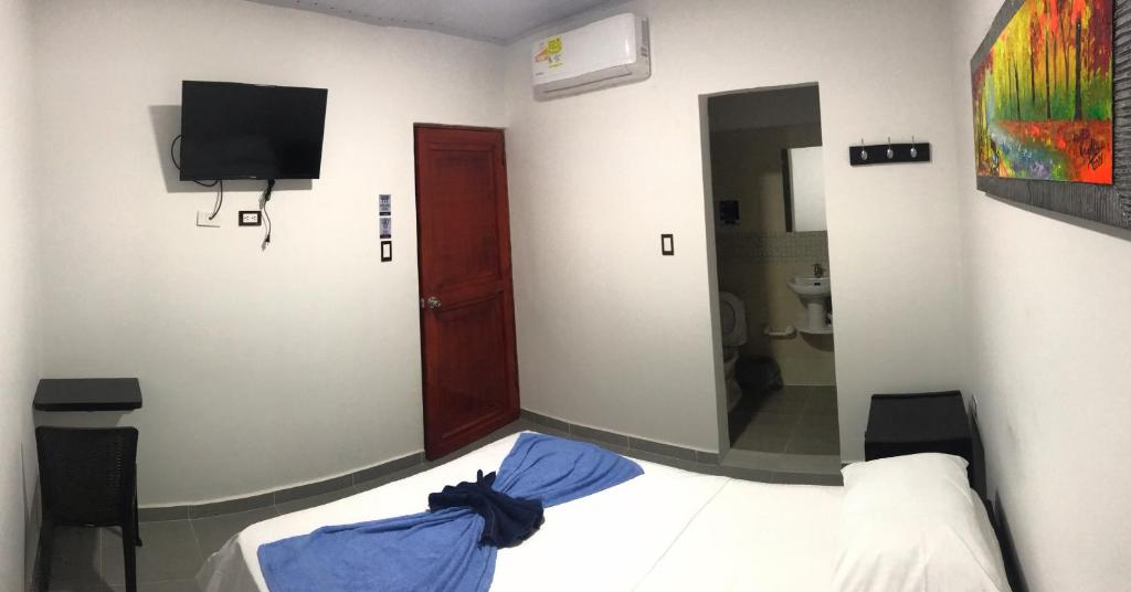 弗洛伦西亚Hotel Inmaculada Real的一间卧室配有一张床和一台电视,还设有一间浴室