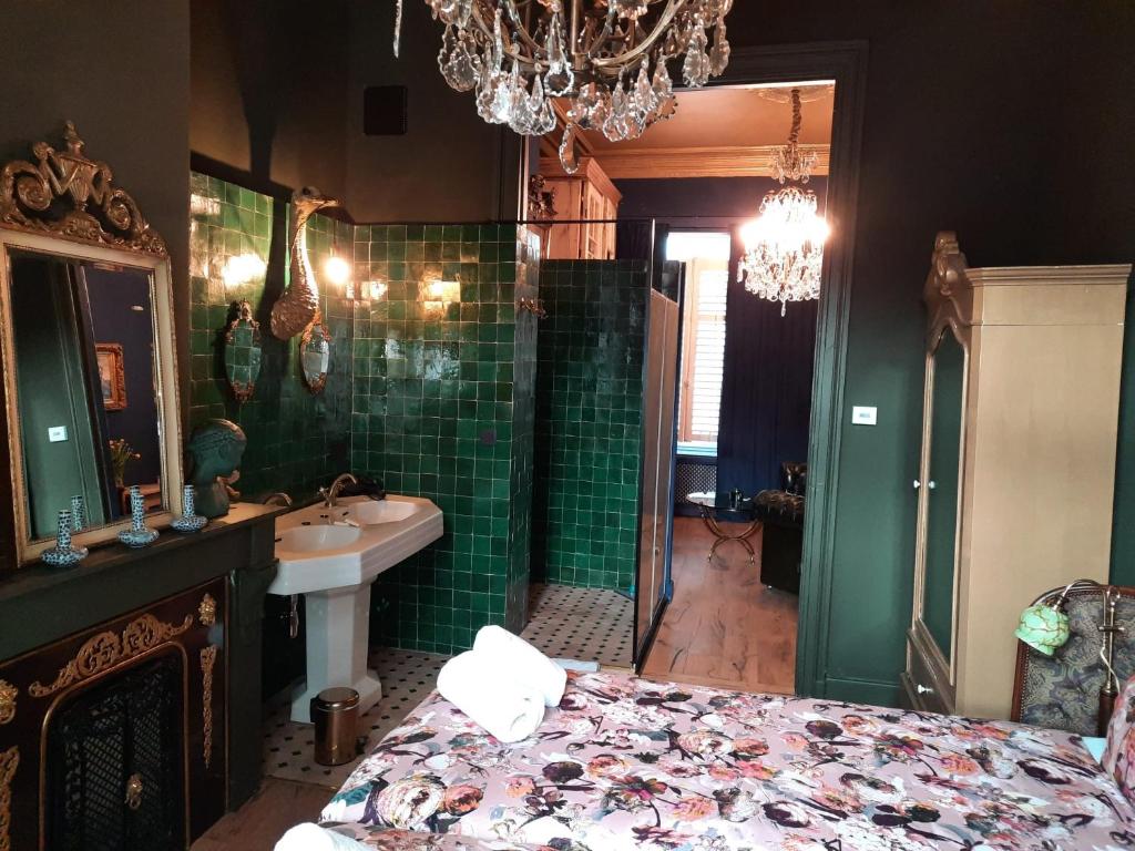 安特卫普Sint Andries Suites的浴室设有床、水槽和吊灯。