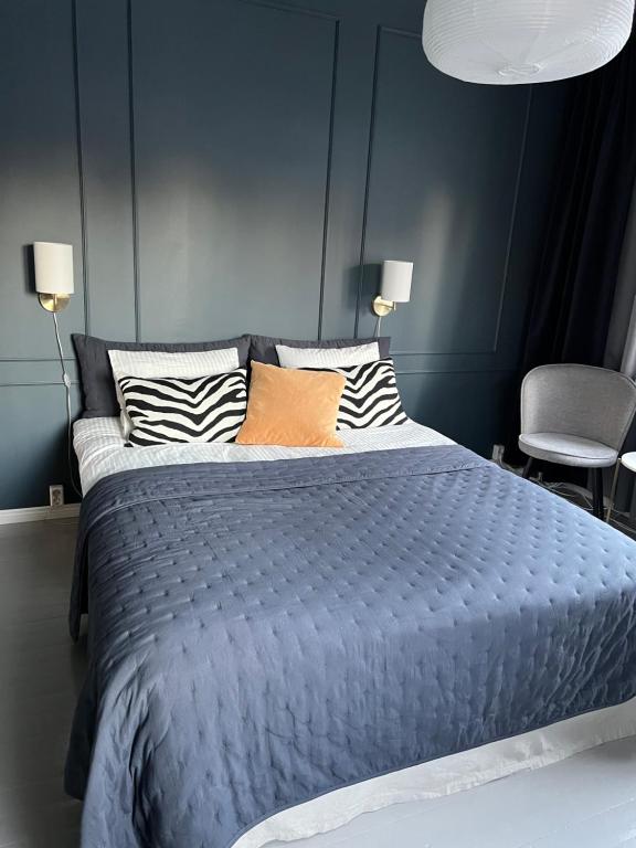 瓦尔考斯The Bird Cherry Junior Suite的蓝色卧室配有一张带枕头的大床