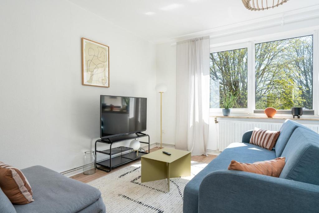 希尔德斯海姆FLATLIGHT - Shiny Apartment - Balcony - Central - Kitchen的客厅配有蓝色的沙发和电视
