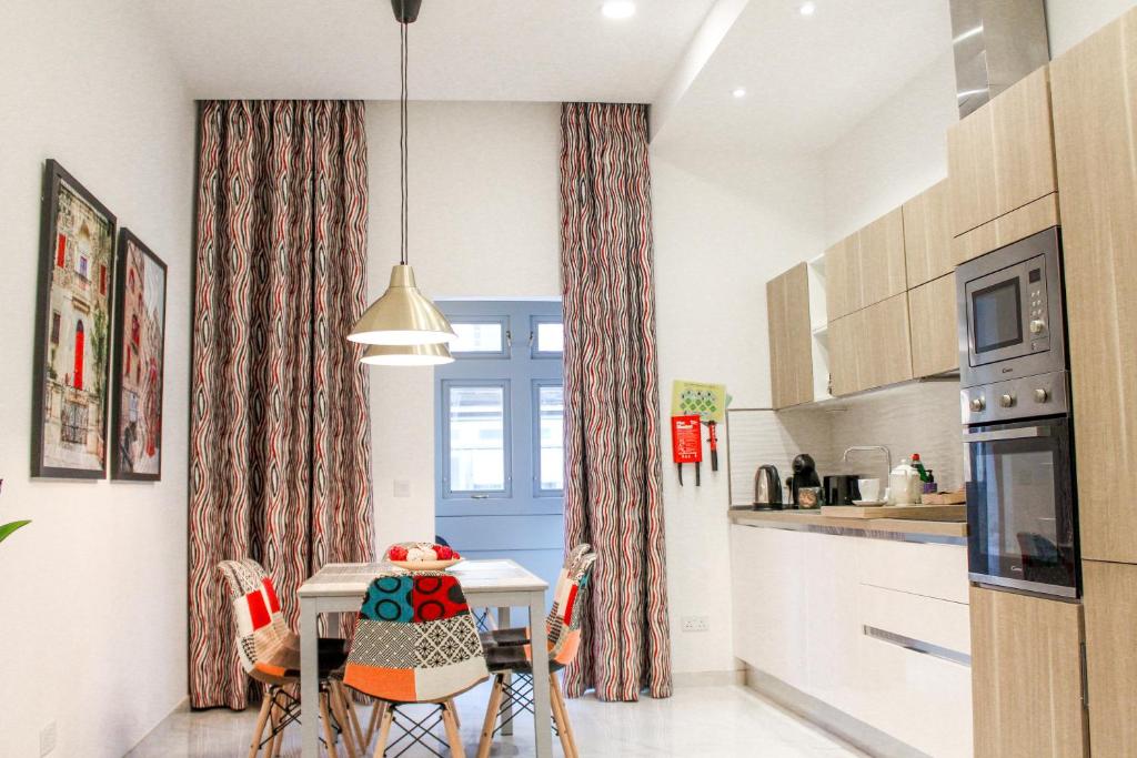 埃尔哥茨拉QLiving Central New Apartments Gzira Sliema Promenade的厨房配有桌椅