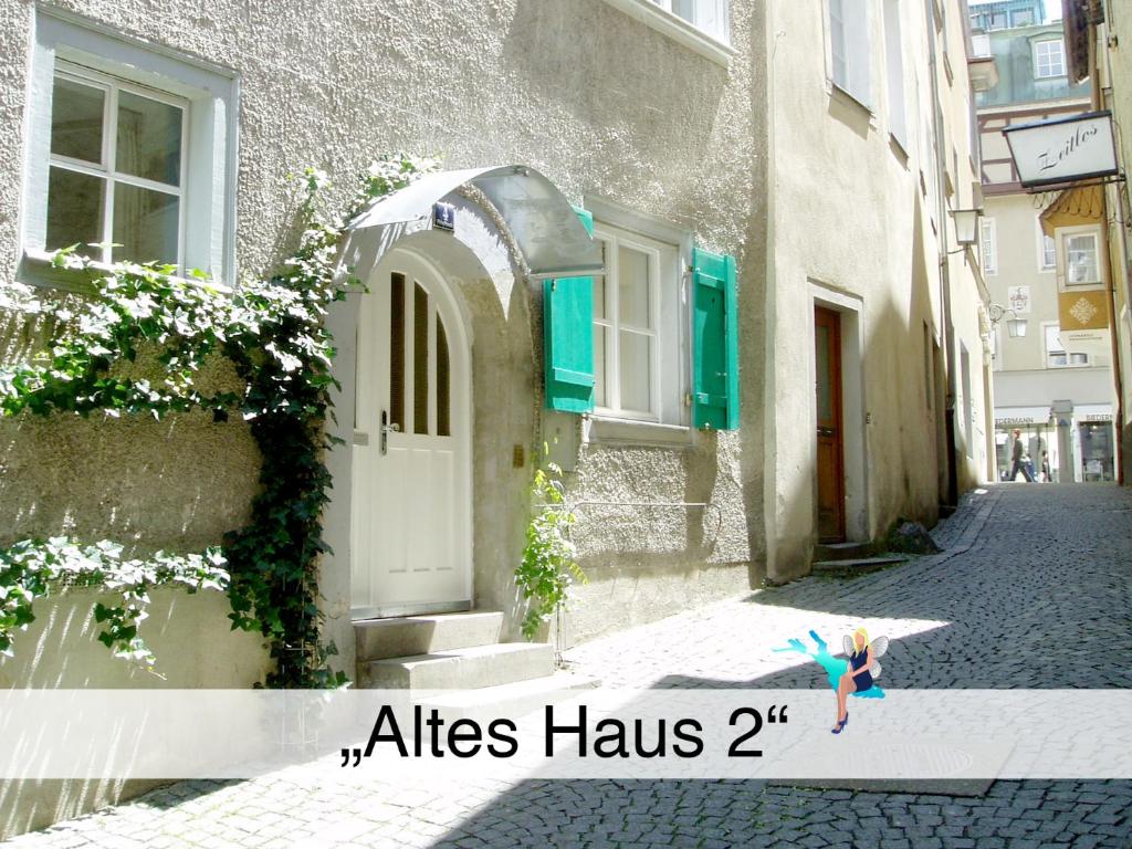 林道Ferienwohnung Altes Haus 2的一个小女孩在街上用雨伞行走