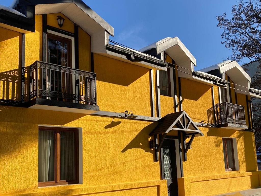 博尔若米Borjomi Yellow Hotel的黄色的建筑,两边有阳台