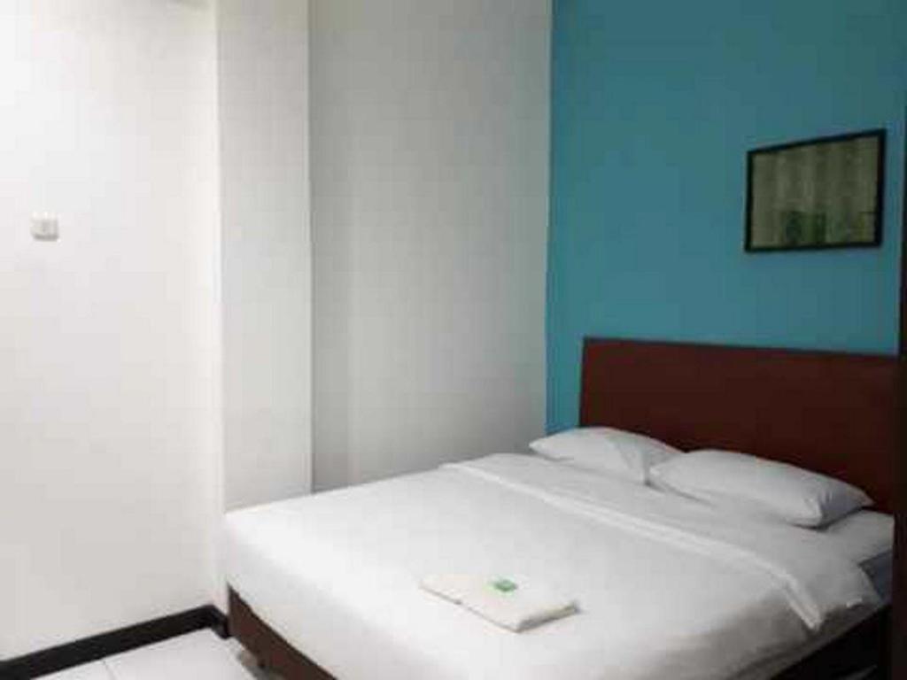 索龙RedDoorz near Dermaga Pelabuhan Rakyat的蓝色墙壁的房间里一张白色的床