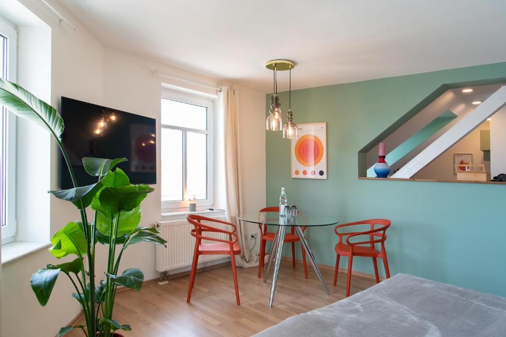 开姆尼茨Bauhaus Apartment - Netflix & Wifi的一间带桌子和红色椅子的用餐室