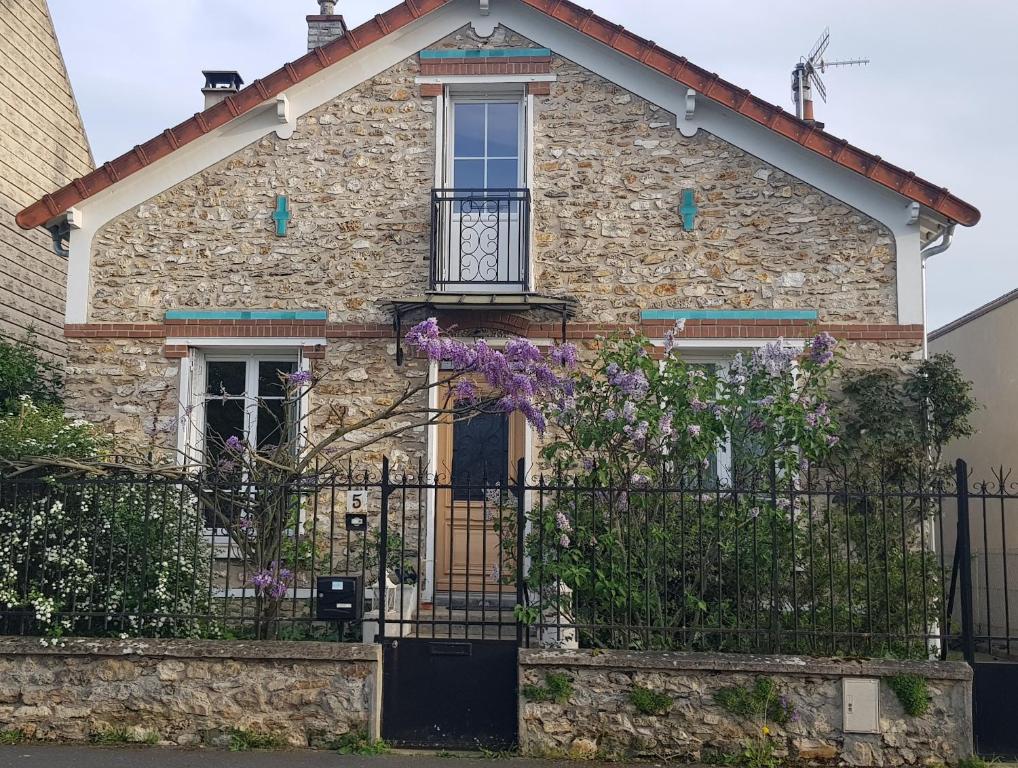 Vaires-sur-MarneLe Vieux Tilleul的石头房子,有门和紫色的花