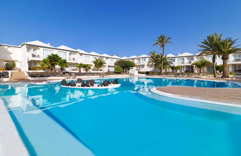 科拉雷侯H10海洋套房酒店的一座棕榈树和建筑的大型游泳池