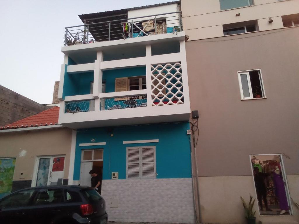 普拉亚In The Heart Of Praia - Family B&B的蓝色和白色的房子,前面有停车位
