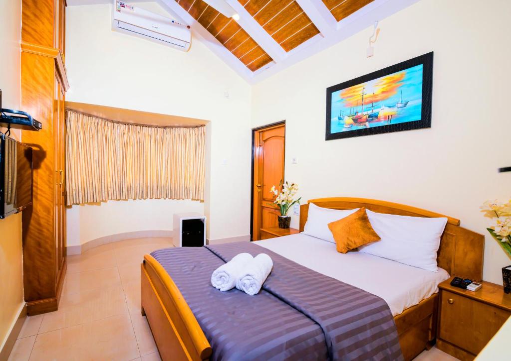 比纳里姆'Golden Oceans' 3 bhk beach view villa的一间卧室配有一张床,上面有两条毛巾