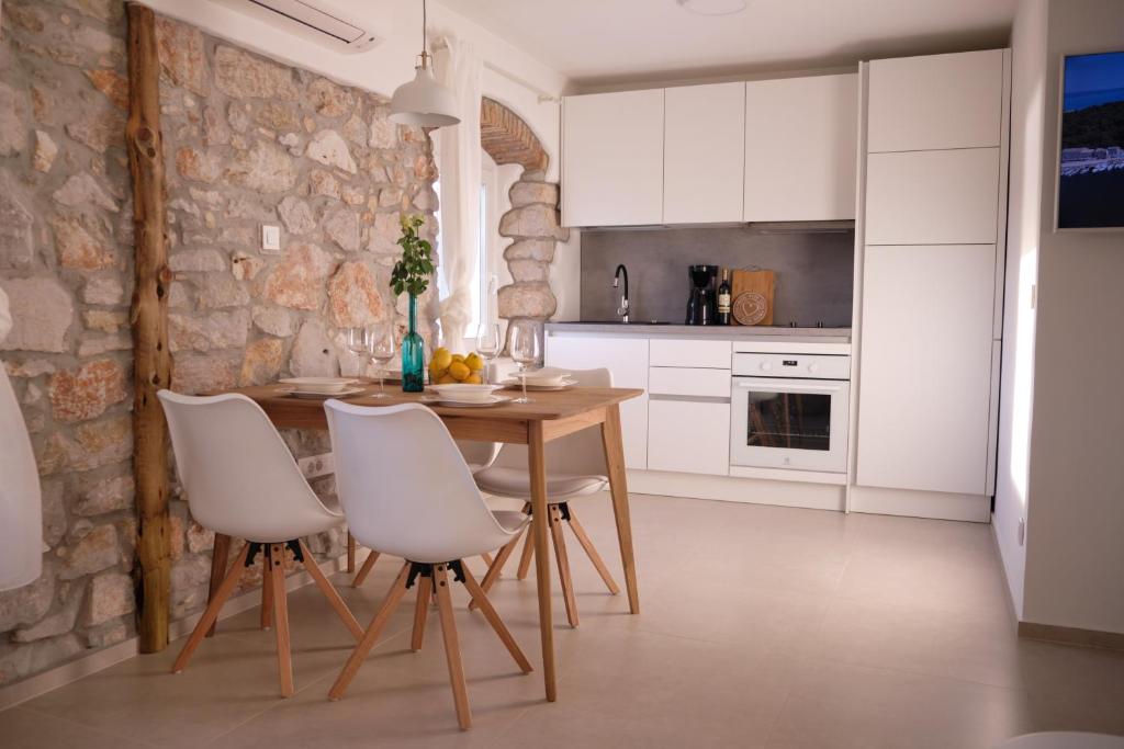 木洛希尼Apartment House Bucul的厨房配有木桌和白色椅子
