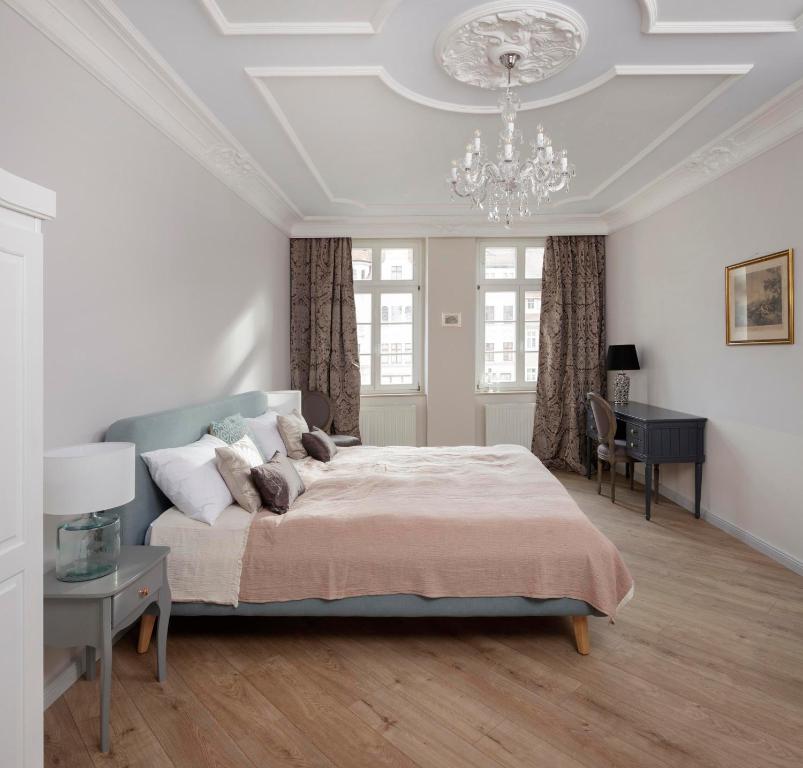 格尔利茨Design-Appartement im Herzen von Görlitz的一间卧室配有一张大床和一个吊灯。