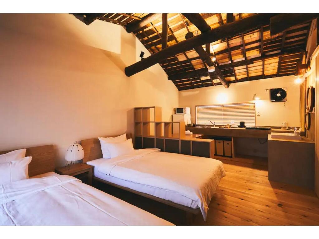 大阪Batonship - Vacation STAY 12907的一间卧室配有两张床和一张书桌。