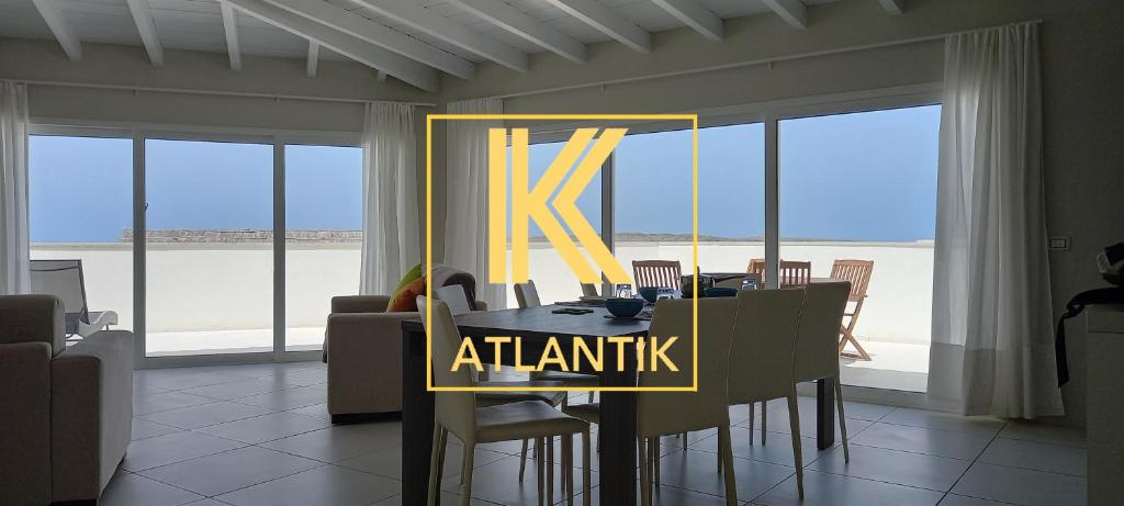 萨尔雷KatlantiK Beach House Deluxe的用餐室,配有带k atantis标志的桌子