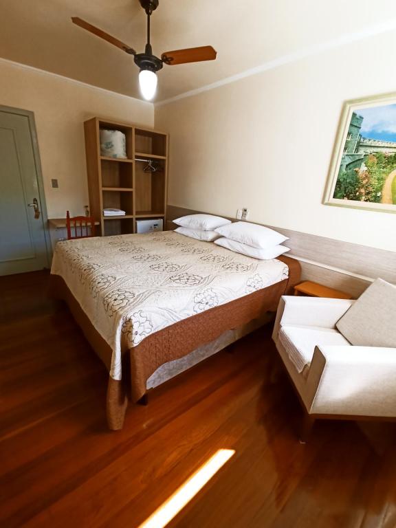 本图贡萨尔维斯Pousada Tedesco的一间卧室配有一张床和吊扇
