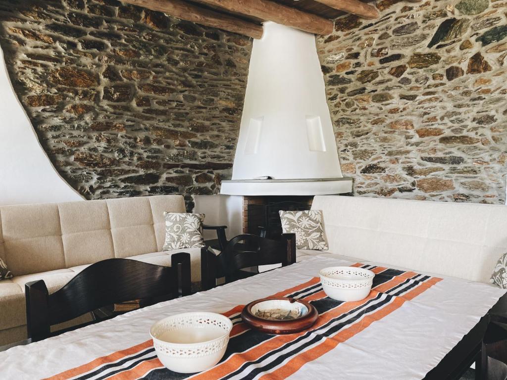 卡利斯托斯Zefis Villas的一间设有桌子和石墙的用餐室