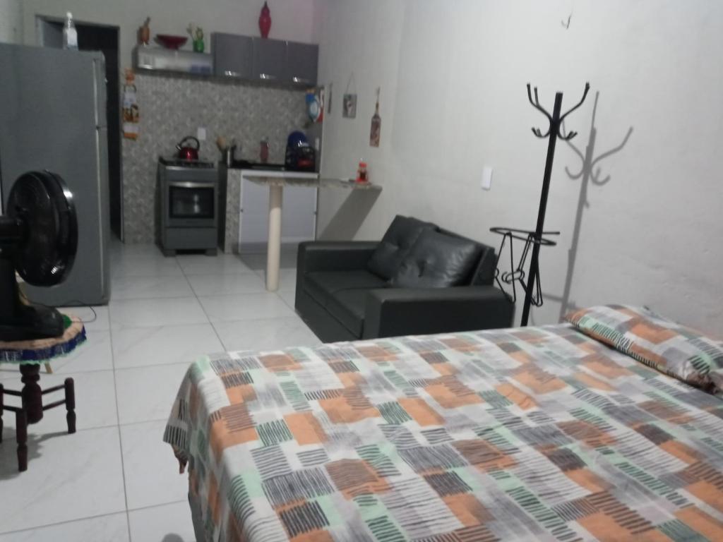 福塔莱萨Kitnet mobiliado, confortável e bem localizado.的一间卧室配有一张床和一张沙发,还设有一间厨房