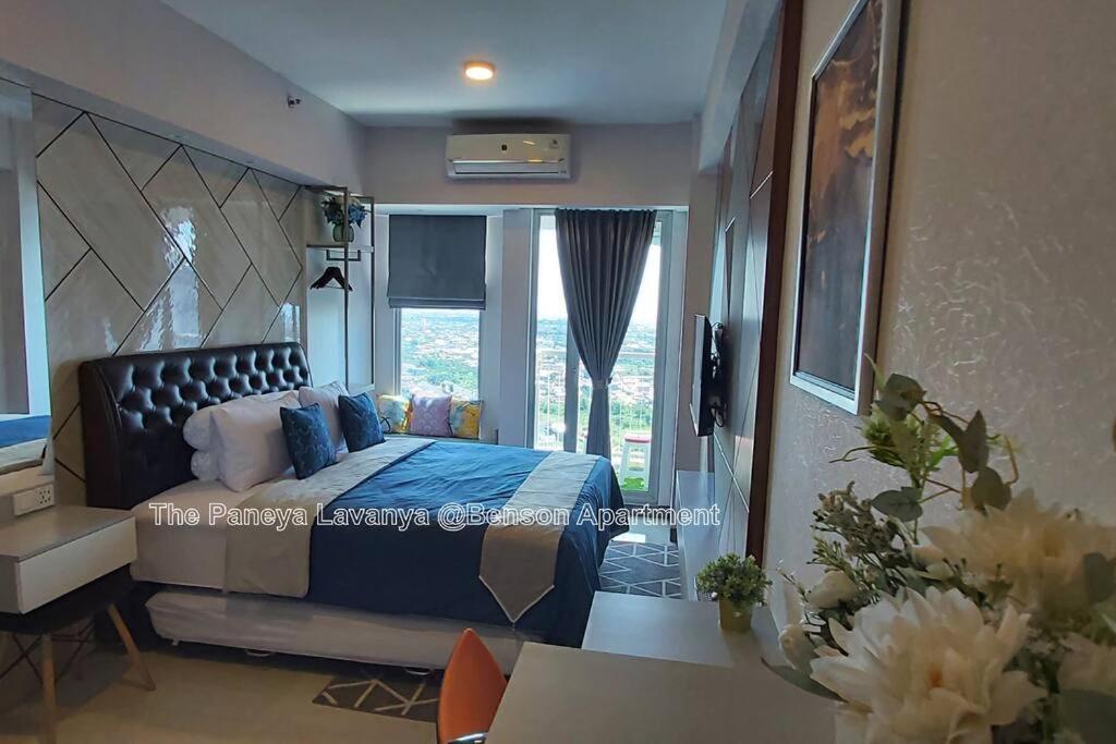 泗水The Paneya Lavanya @Benson Apartment的一间卧室配有一张带蓝色毯子的床和窗户。