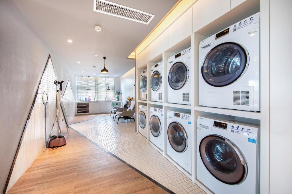 昆明昆明滇池西山区政府亚朵酒店的洗衣房配有一排洗衣机和烘干机
