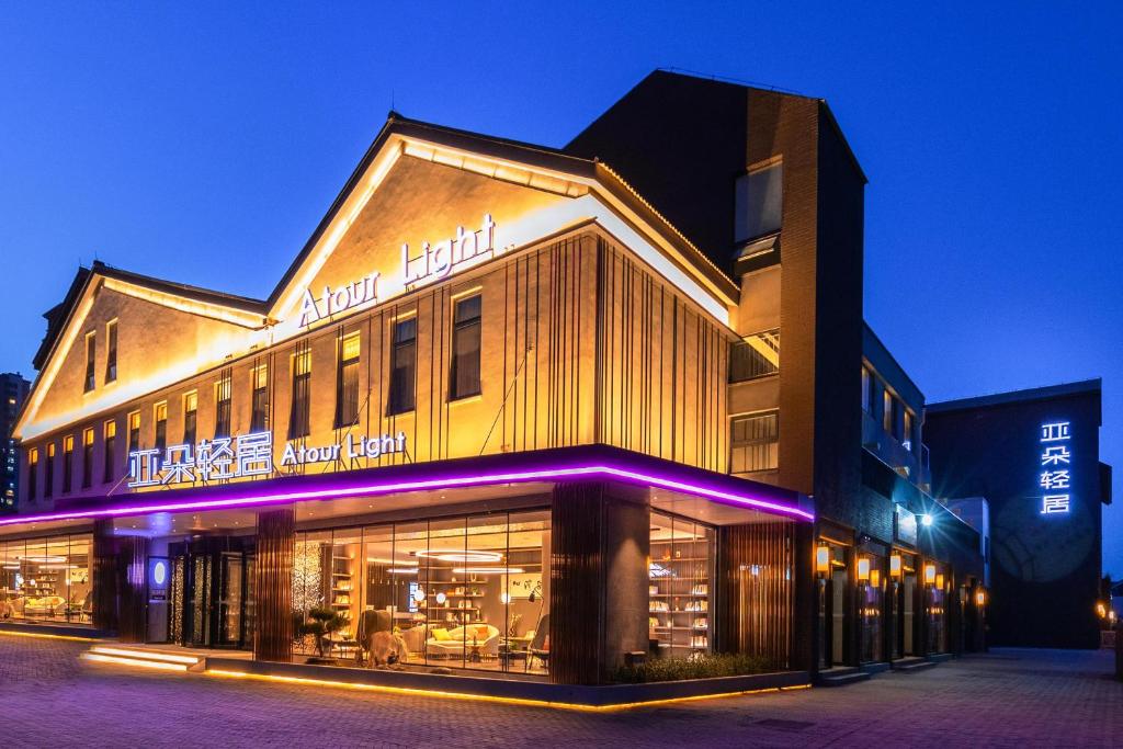 济南济南西站国际会展中心亚朵轻居酒店的建筑的侧面有紫色的灯