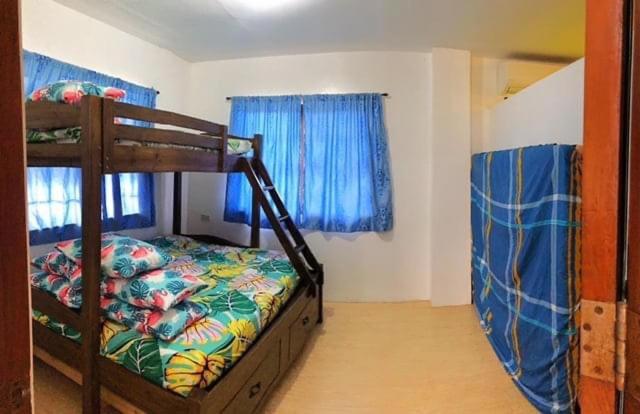 卡兰巴Deluxe Villa Leah Natural Hotspring Resort的一间卧室配有双层床和蓝色窗帘
