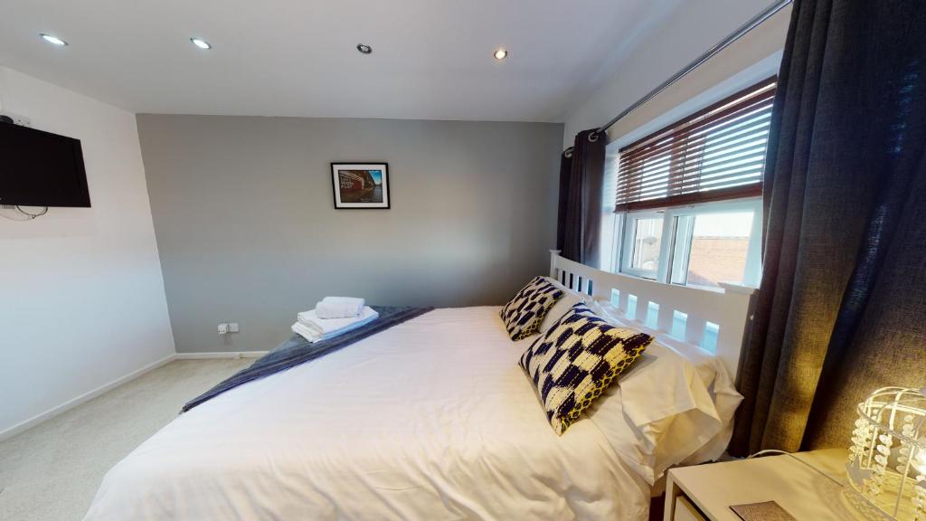 赫尔Victoria House的卧室配有带枕头的床铺和窗户。