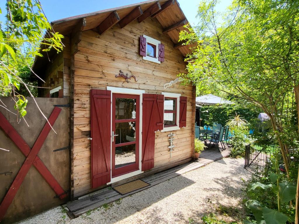 La Barriérele petit chalet cevenol的小木屋设有红色的门和窗户