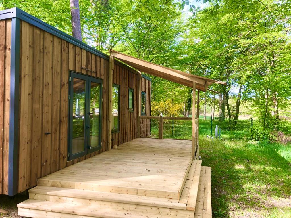 Vieilles-Maisons-sur-JoudryCAMPING ETANG DES BOIS的森林中木人行道的小木屋