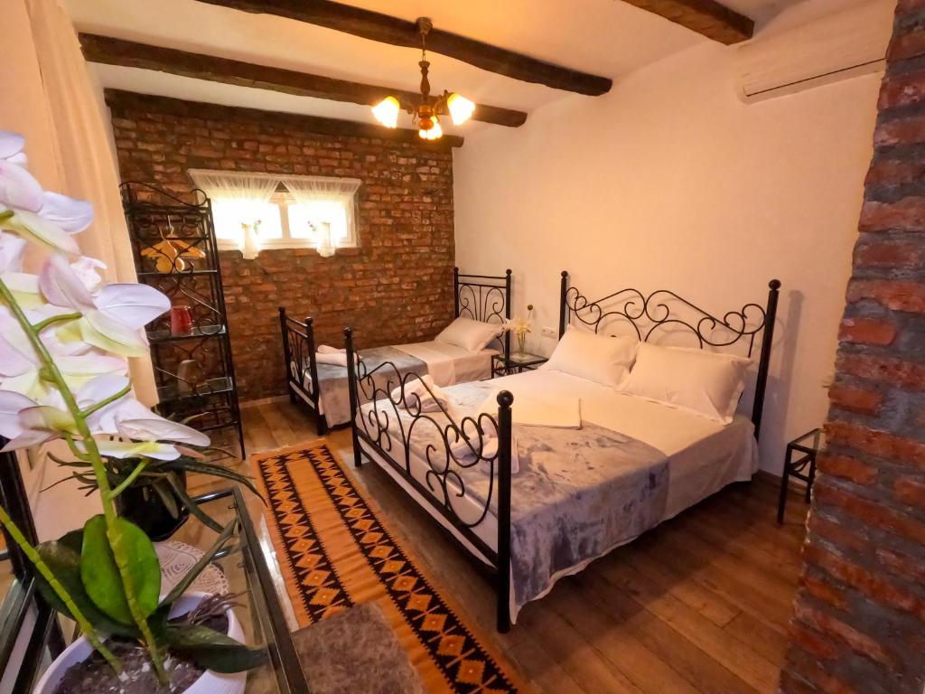 斯库台InTown Guesthouse Shkoder的一间卧室设有两张床和砖墙