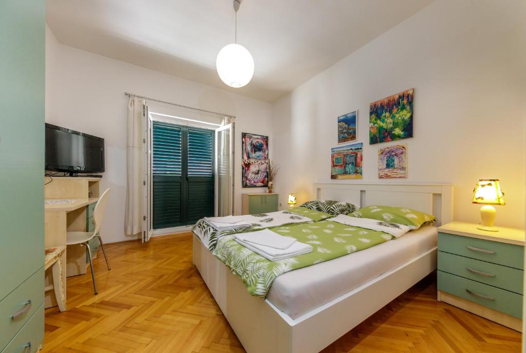 杜布罗夫尼克托哈公寓的一间卧室配有一张床、一张书桌和一台电视