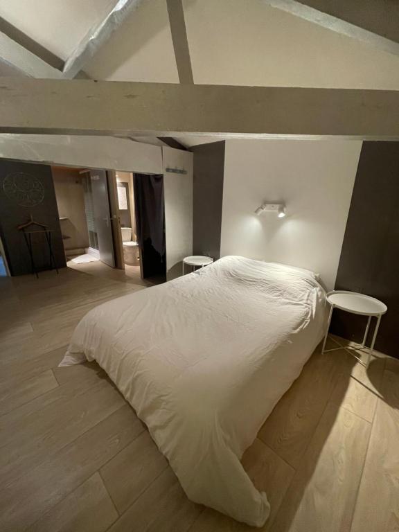 Saint-Yzans-de-MédocMaison d'Hôtes - Le Logis du Médoc的卧室配有白色的床和2张凳子