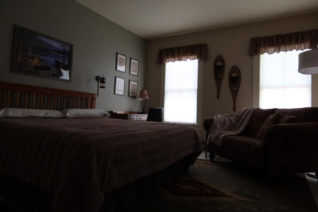 WestportThe Inn in Westport的一间卧室配有一张床、一张沙发和窗户。