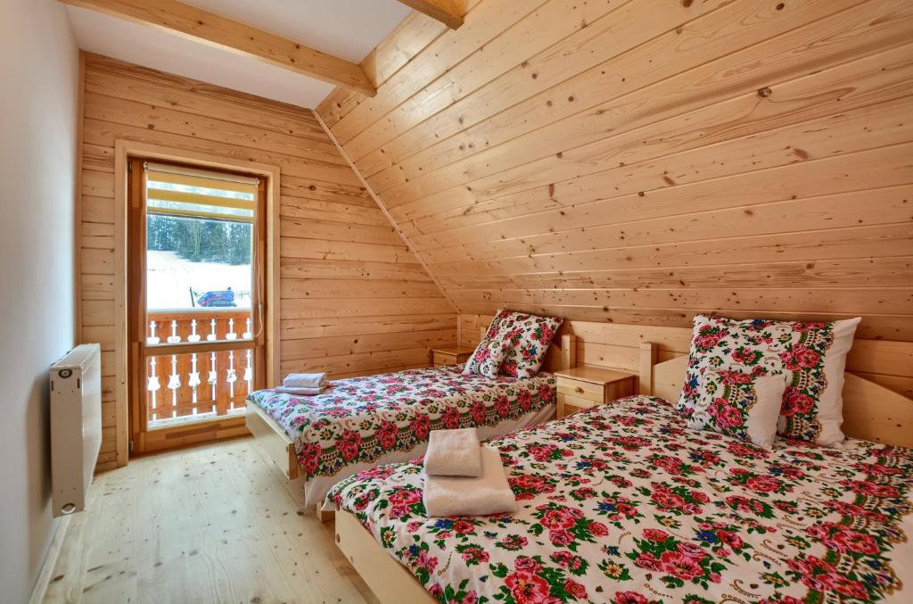布科维纳-塔钱斯卡Domki Stochowa Śleboda的小木屋内一间卧室,配有两张床