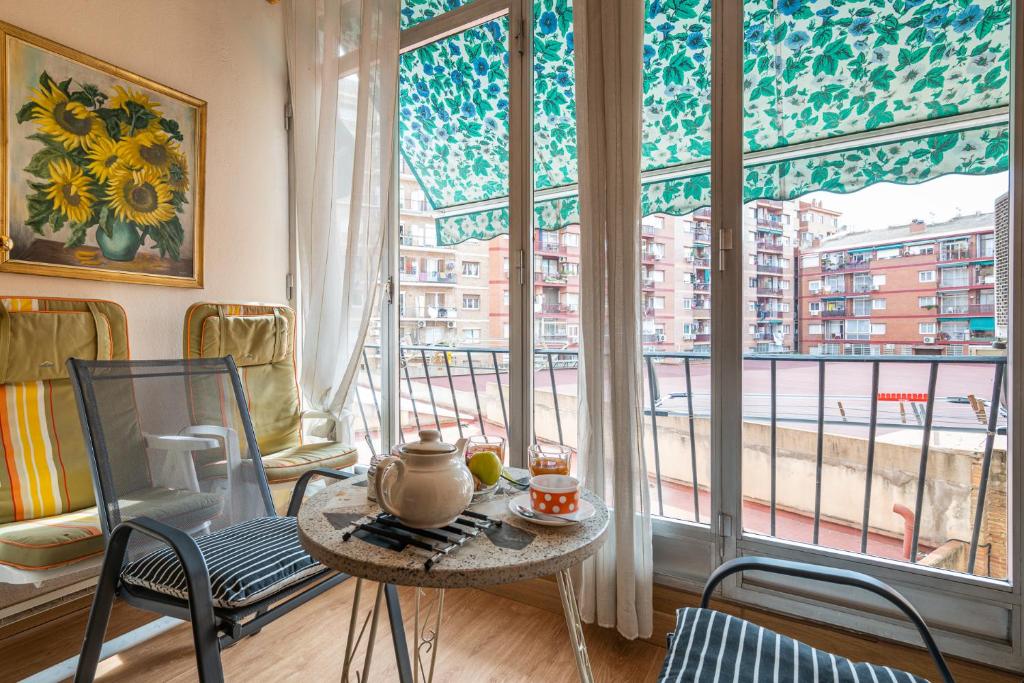 巴塞罗那Flat Meridiana的客房设有桌椅和大窗户。