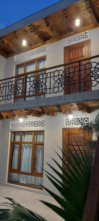 布哈拉Bukhara Baraka Boutique Hotel的带阳台的白色建筑和棕榈树