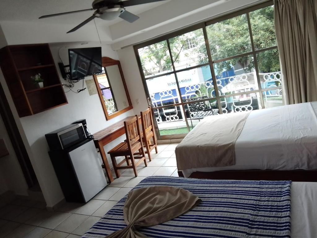 普拉亚卡门CASA BARKA的酒店客房设有两张床和电视。