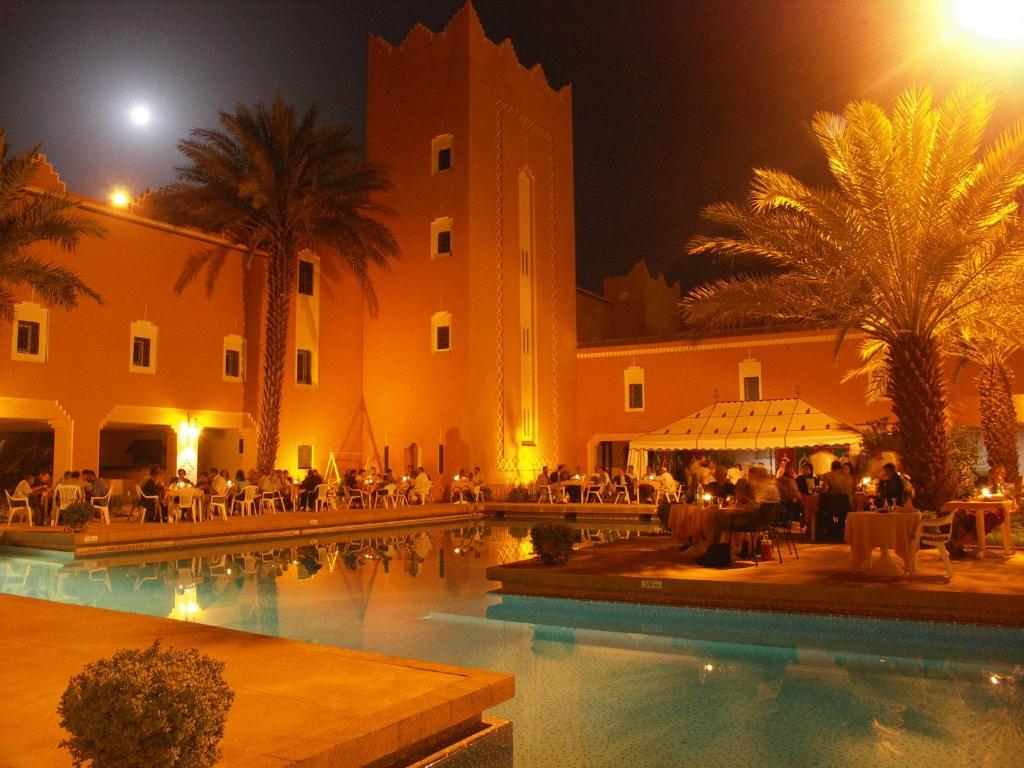 扎古拉Hôtel Le Tinsouline的夜间设有游泳池的酒店