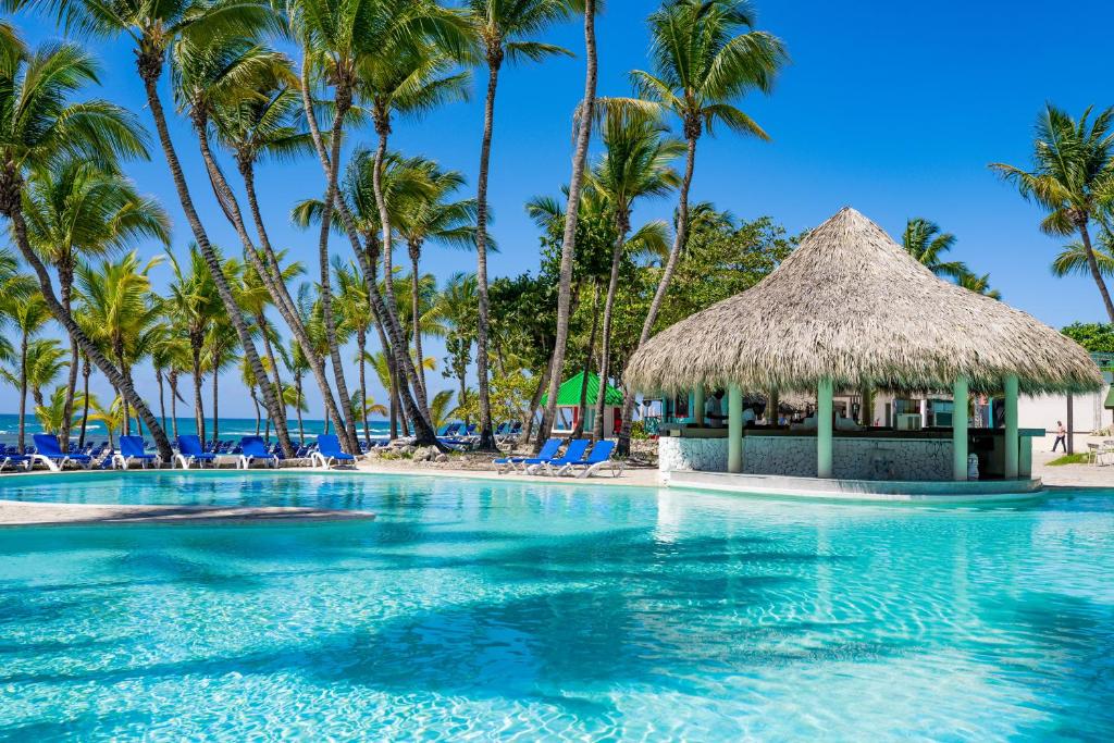 璜多里奥Coral Costa Caribe Beach Resort - All Inclusive的一座棕榈树游泳池和小屋