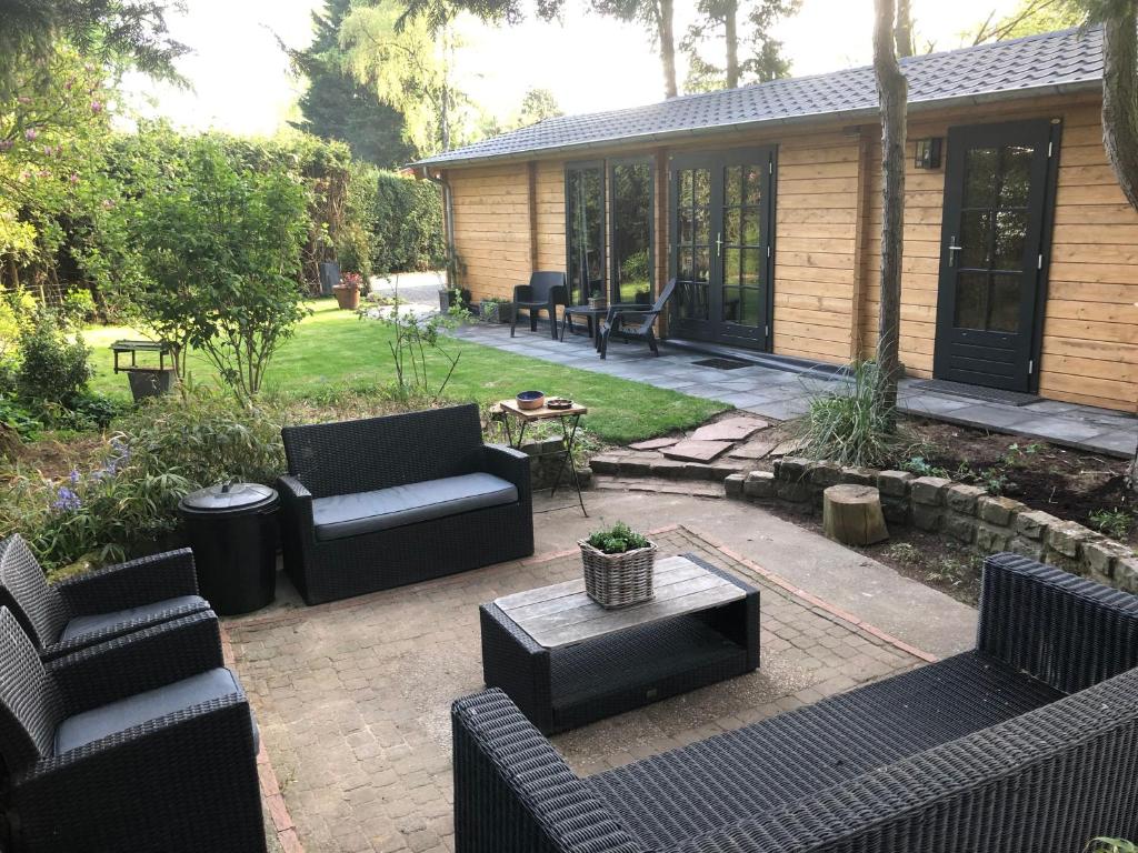 皮滕Kom tot rust op de Veluwe in nieuwe unieke blokhut的庭院里设有沙发和桌子