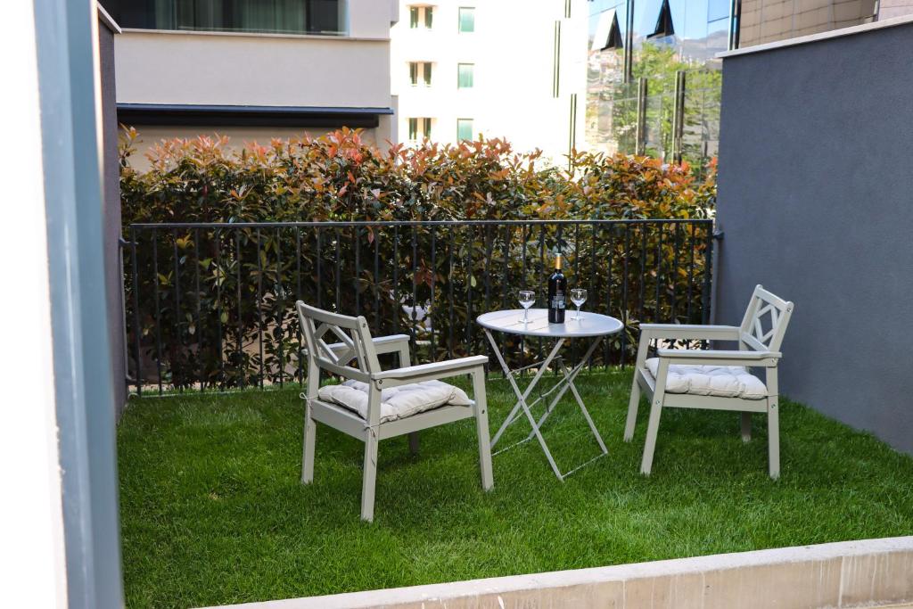 杜布罗夫尼克Studio apartmani GITA GARDEN的草坪上一张桌子和两把椅子以及一张桌子