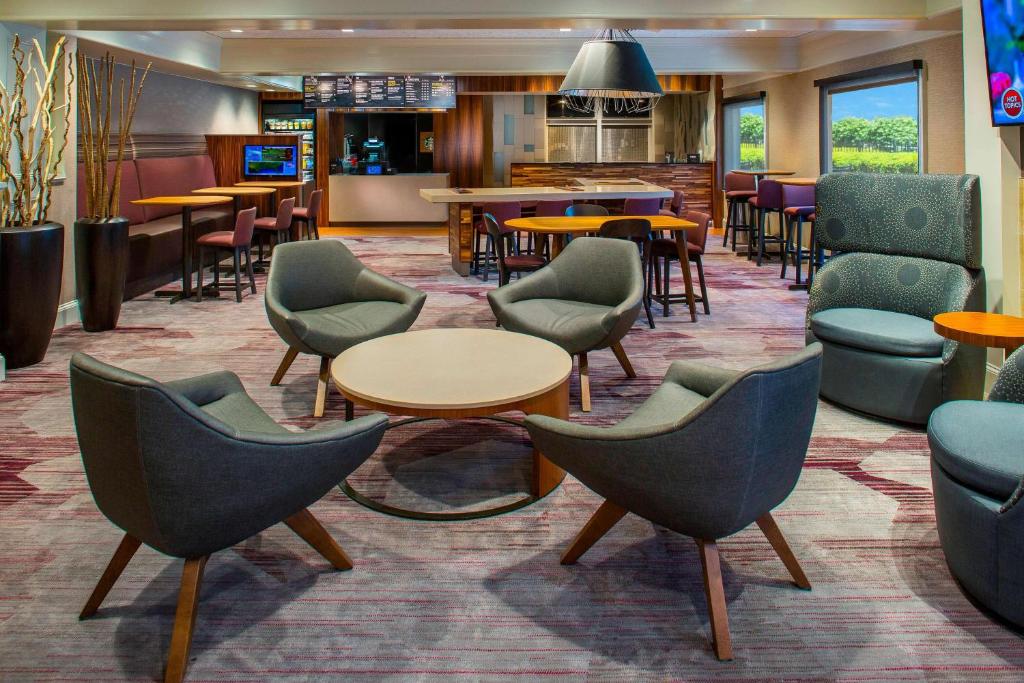 洛厄尔波士顿罗威尔切姆斯福德庭院酒店的大堂设有桌椅和酒吧。