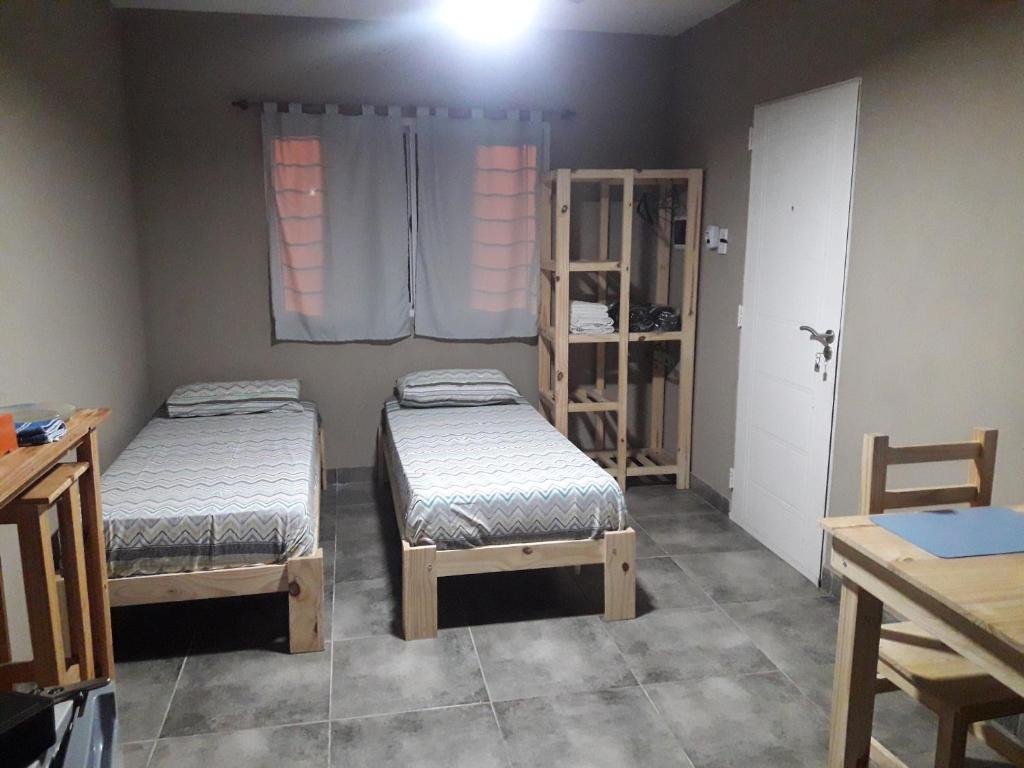 富内斯Cabañas Samay的客房设有两张床、一张桌子和一扇窗户。