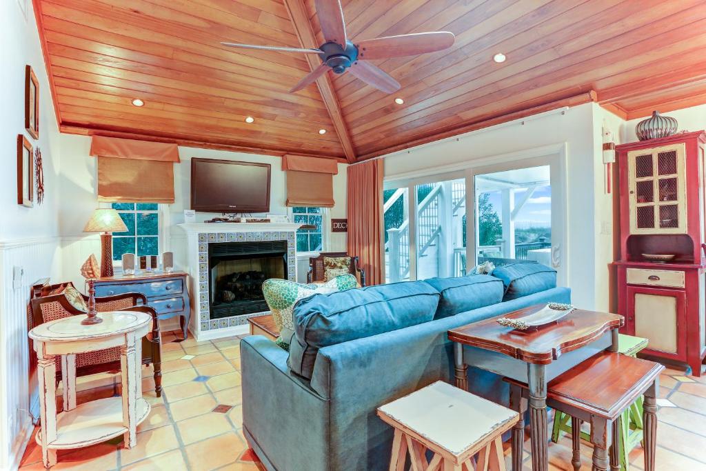 费南迪纳比奇Ocean Ave Seaside Cottage的客厅配有蓝色的沙发和电视