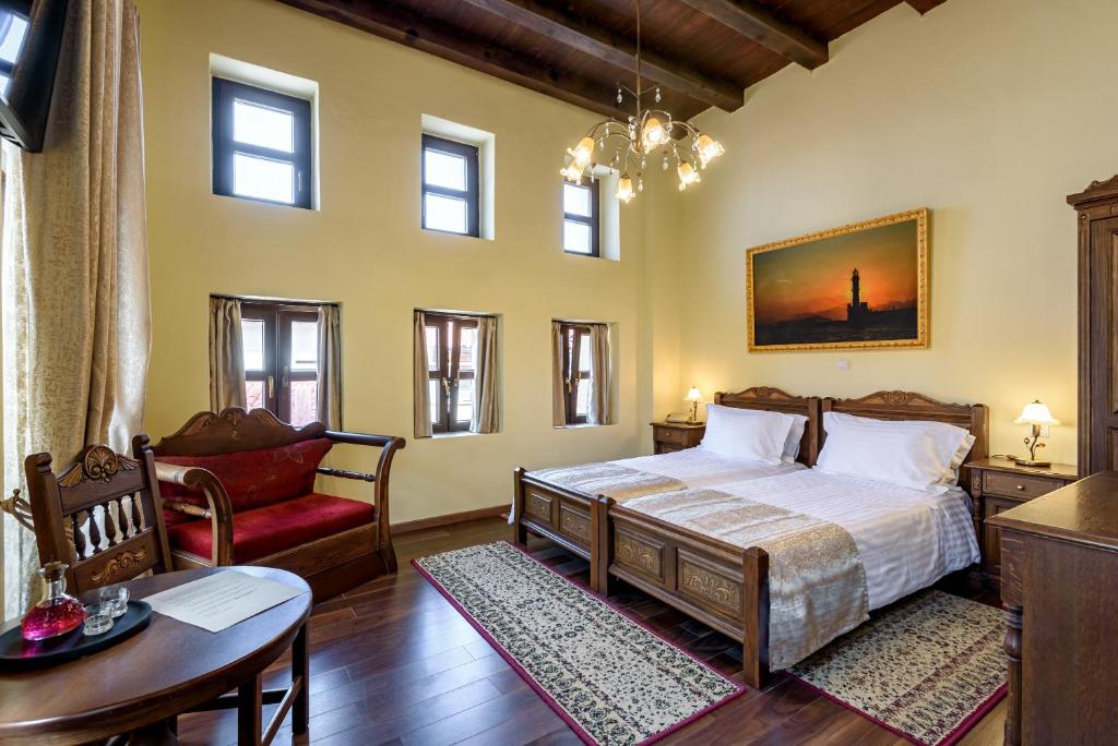 干尼亚波尔图德尔科伦坡传统精品酒店的一间卧室配有一张床、一把椅子和一张桌子
