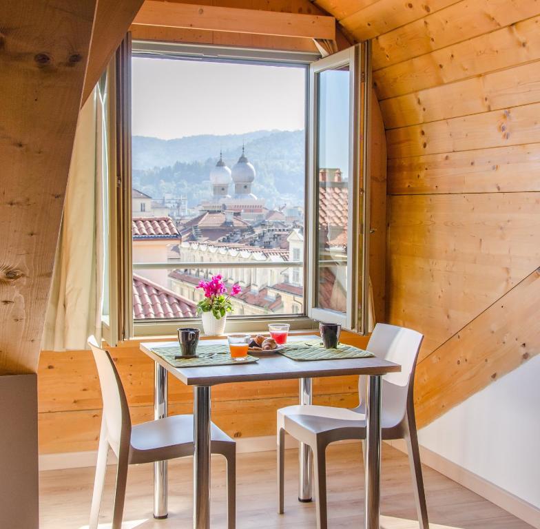 都灵Turin Sweet Home的配有大窗户的客房内的桌椅