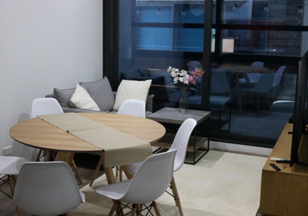 墨尔本MELBOURNE STAR APARTMENT的一间带桌椅和沙发的用餐室