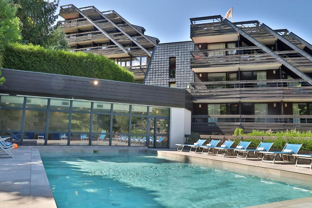 圣热尔韦莱班SOWELL HOTELS Mont Blanc et SPA的一座带椅子的建筑前的游泳池