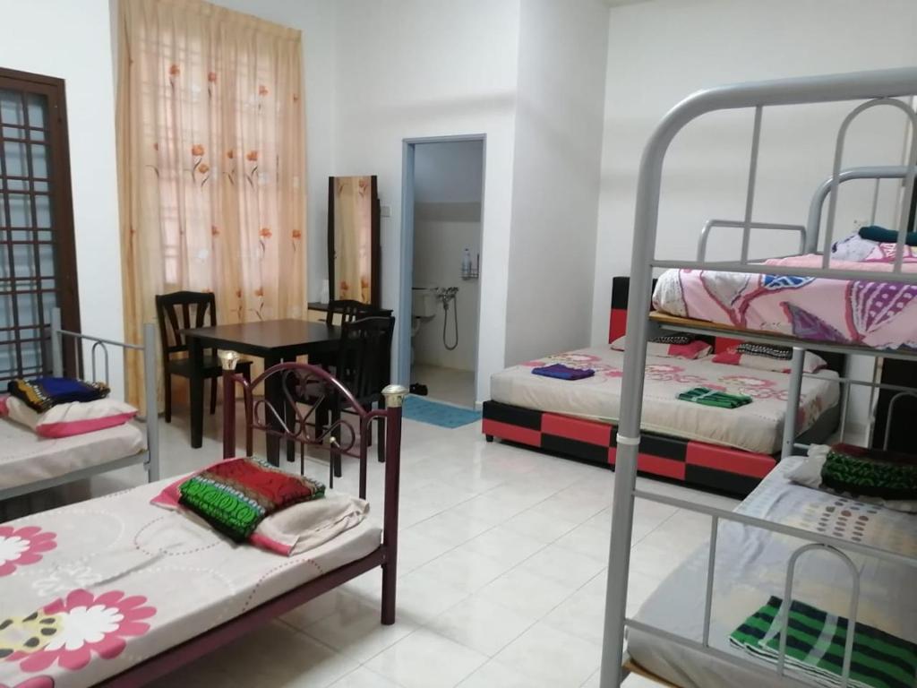 麻坡JOYFIN homestay roomstay muar的客房设有两张双层床和一张桌子。
