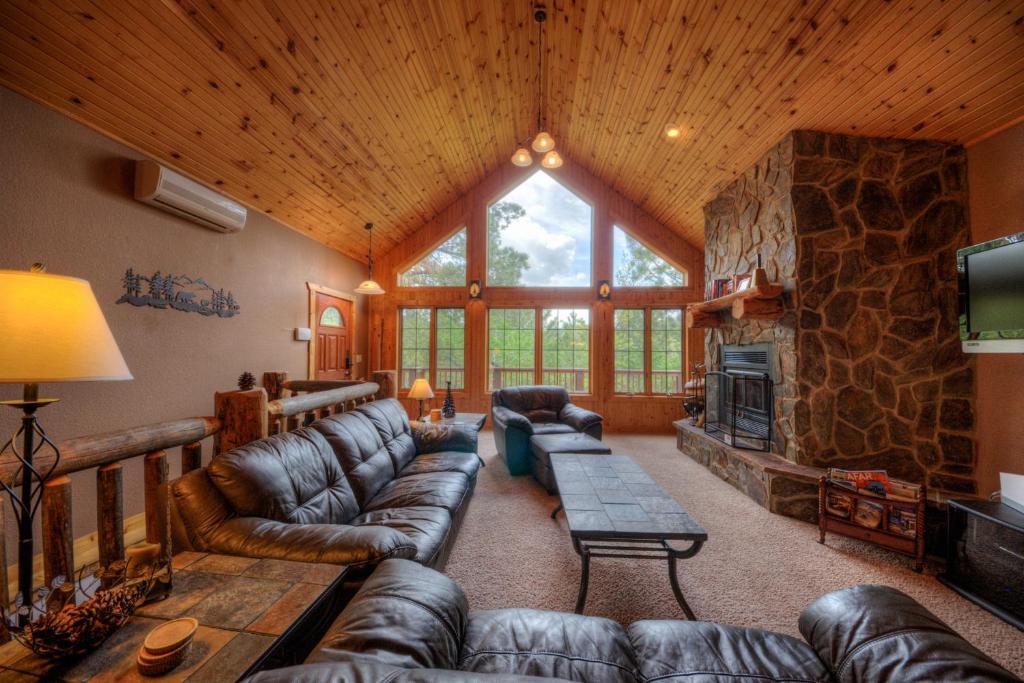 斯特吉斯Lazy Bear Lodge的客厅设有真皮沙发和石制壁炉