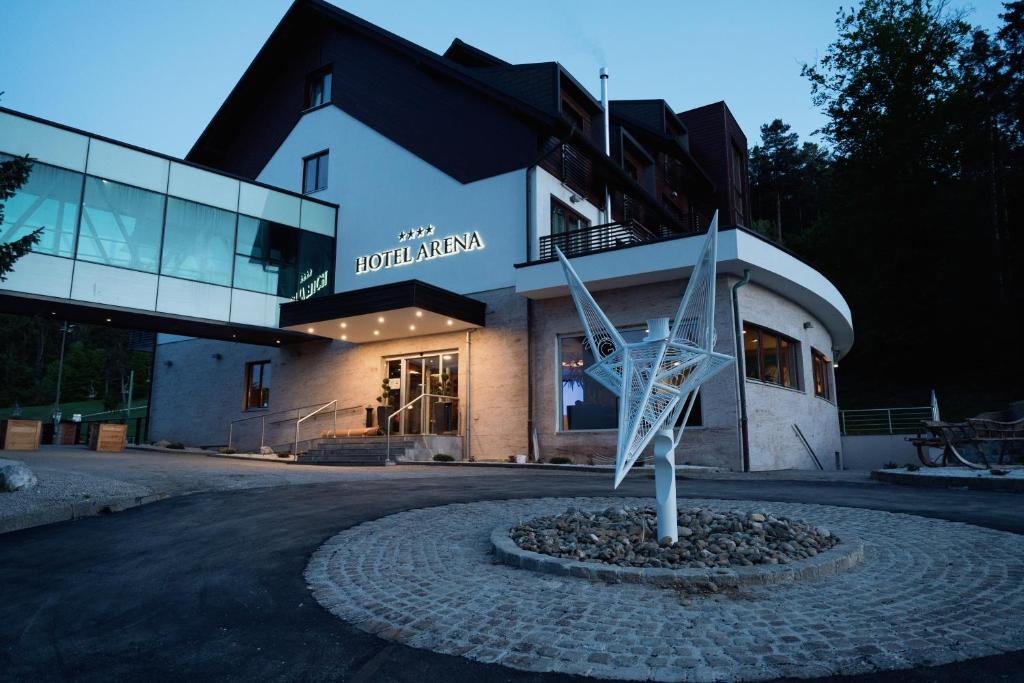 马里博尔Hotel Arena Maribor的前面有雕塑的建筑