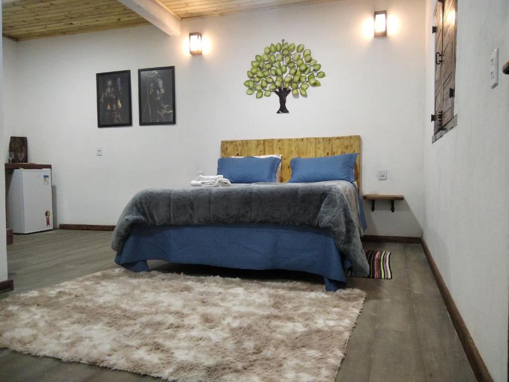 拉夫拉斯诺瓦斯Chalé Suite do chá的一间卧室配有一张带蓝色床单和地毯的床。